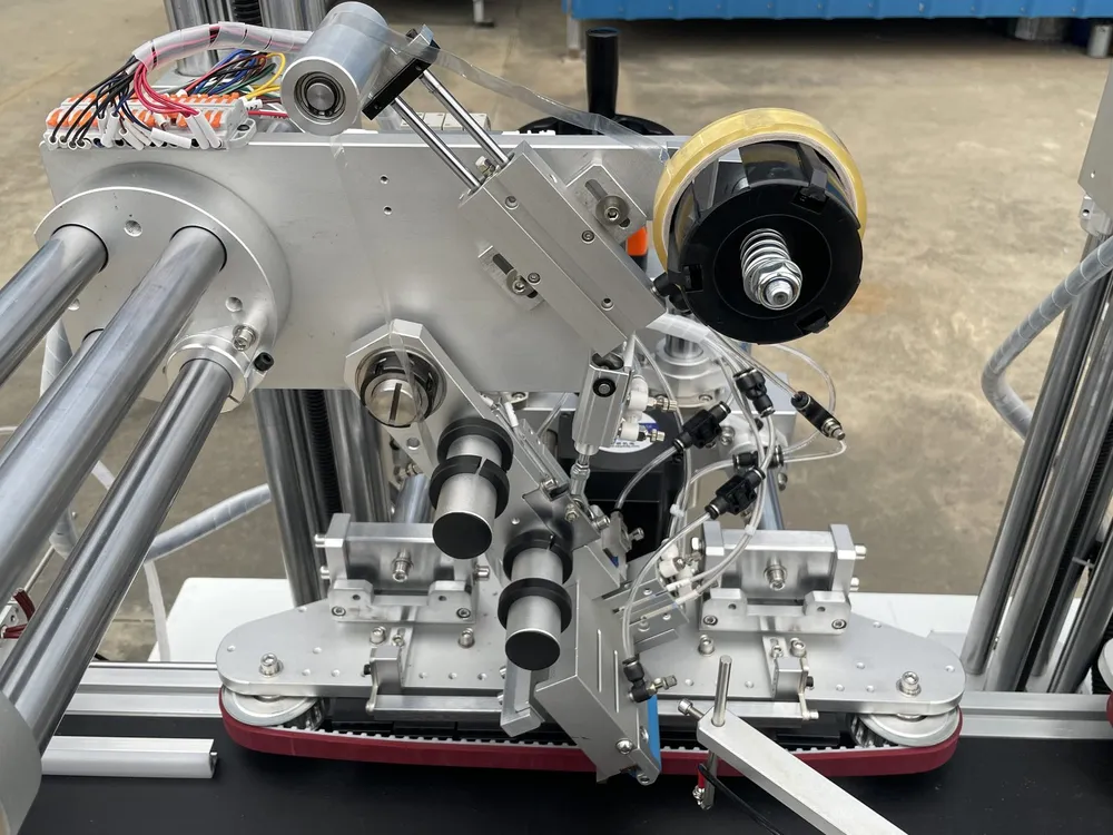 Clamping-Belt Dual-Head Tape Applicator — Tape head close-up: tape reel, rollers and pneumatic cylinders